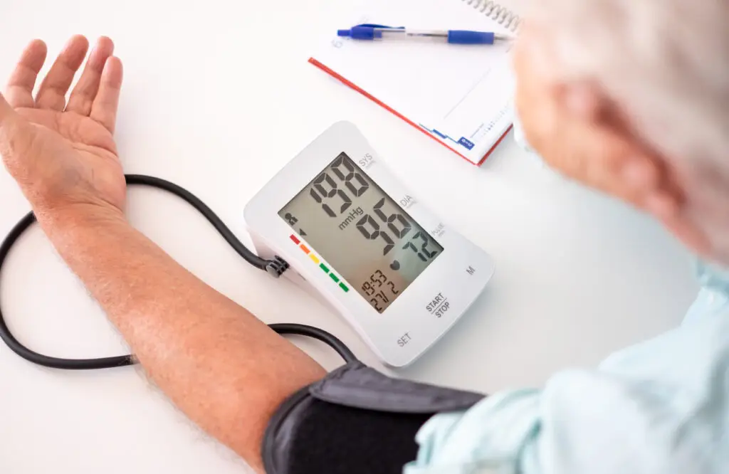 Person measuring blood pressure with a digital monitor